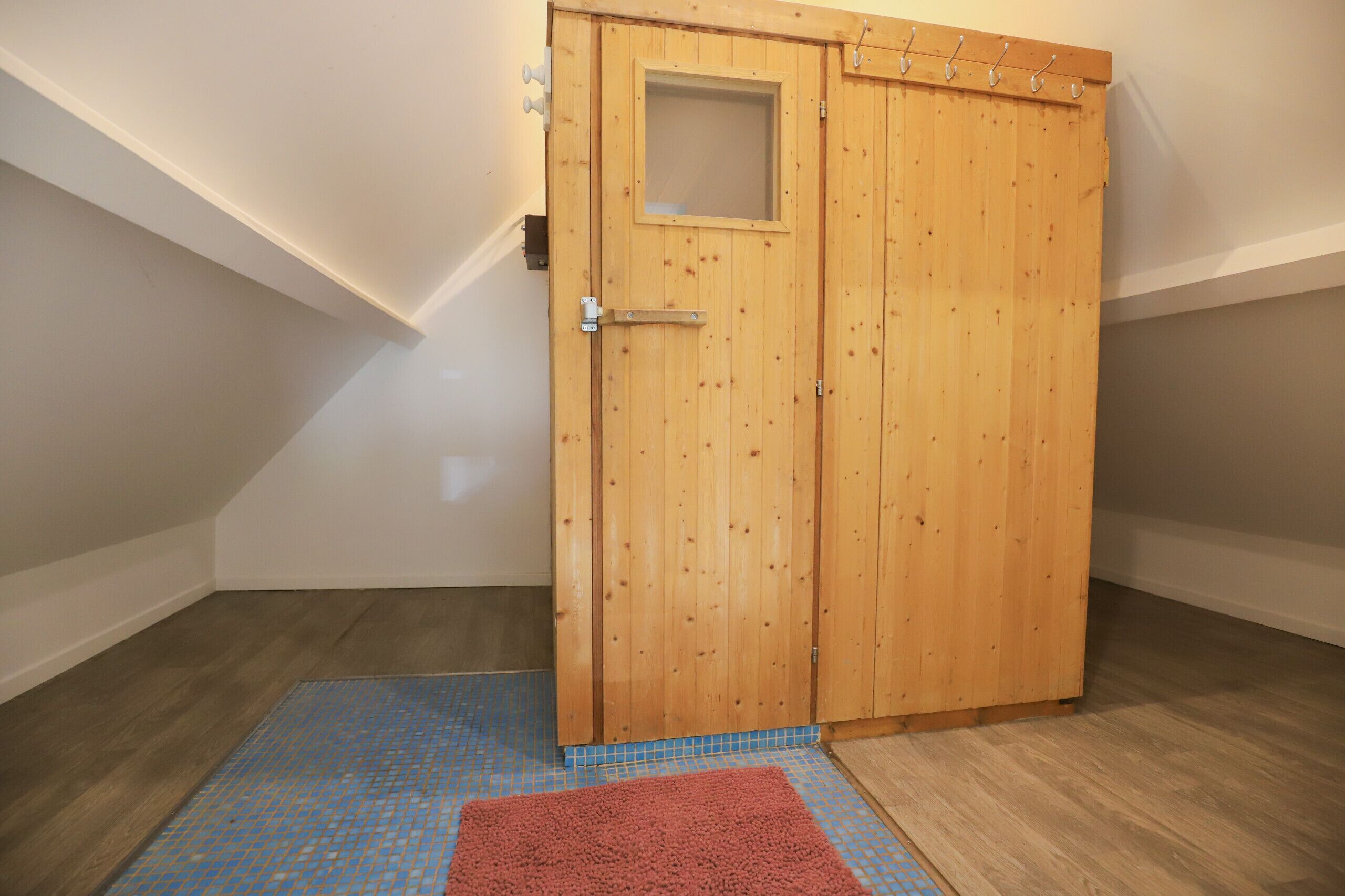 A wooden door with a small window and a metal handle.
