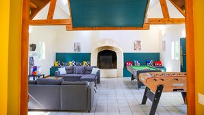A cozy indoor space with a sofa, a foosball table, and a fireplace. - Crazy Villa Ecottay (61) - Heated pool - 2h from Paris - 30p. (Longny les Villages)