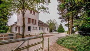 A two-story building with a gravel driveway and a wooden fence. - Crazy Villa Radar (89) - Heated pool - Multisports field - 2h Paris - 30p. (Saint-Cyr-les-Colons)