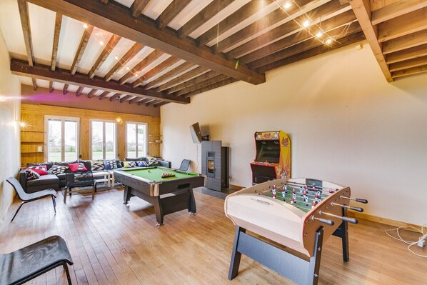 A cozy indoor space with a pool table, foosball table, and a sofa area. - Crazy Villa Radar (89) - Heated pool - Multisports field - 2h Paris - 30p. (Saint-Cyr-les-Colons)