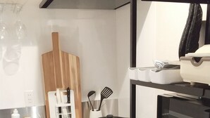 Eine kleine Küche mit Mikrowelle, Backofen und Geschirrgestell.