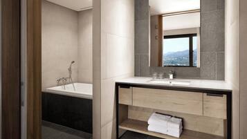 A modern bathroom with a bathtub, a sink, and a mirror.
