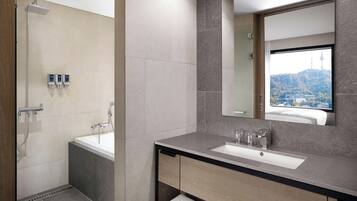 Un bagno moderno con vasca, doccia e lavabo.