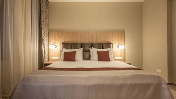 Habitación de hotel con una cama grande, dos mesitas de noche y un cabecero con iluminación integrada.