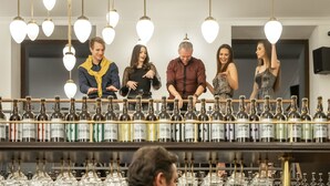 A group of people standing in a bar area with numerous bottles and glasses on shelves. - EFI SPA Hotel Superior & Pivovar (Brno)