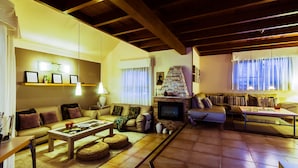 A cozy living room with a fireplace, comfortable seating, and a television.