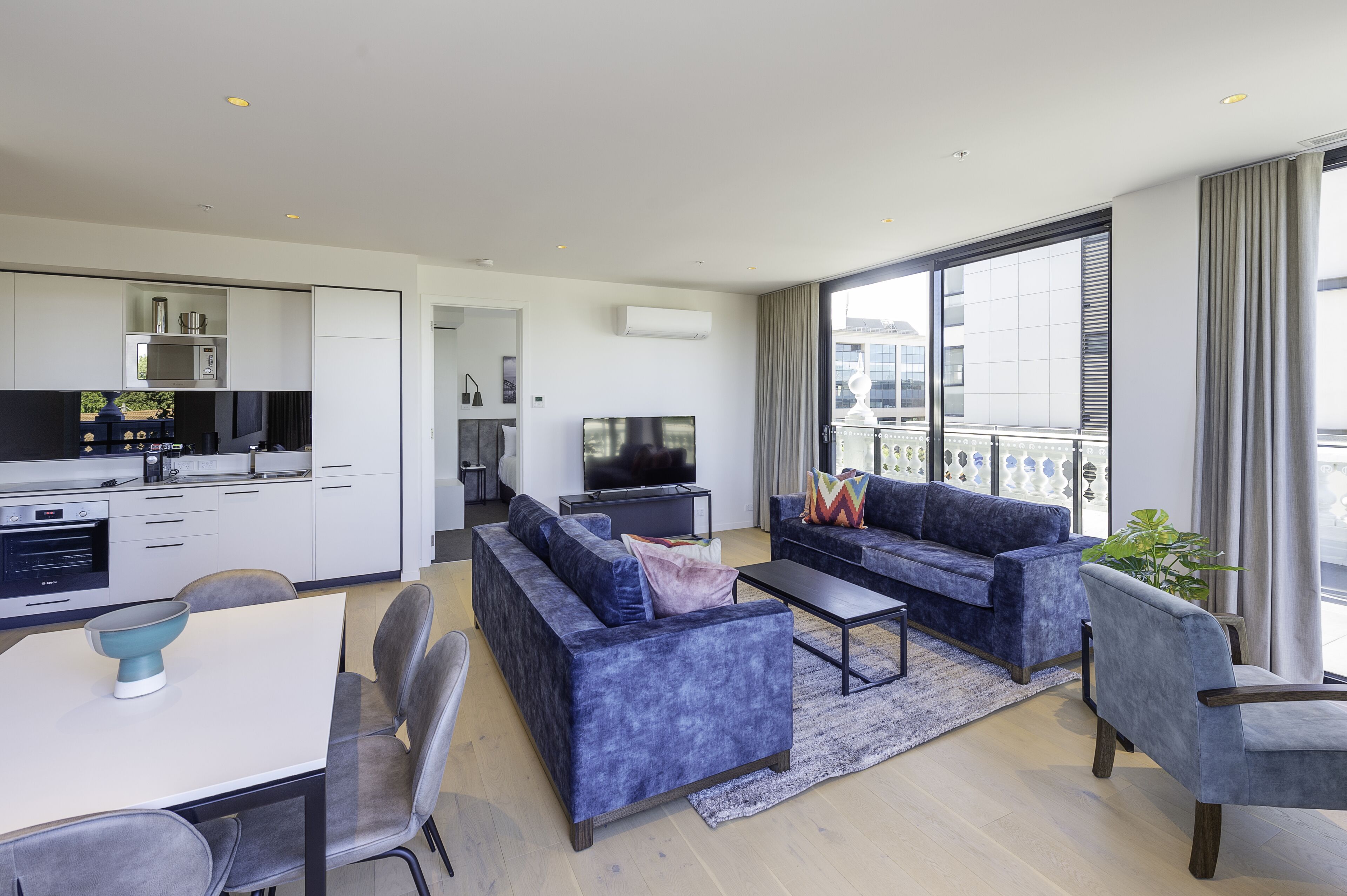 Een modern appartement met keuken, eethoek en woonkamer.