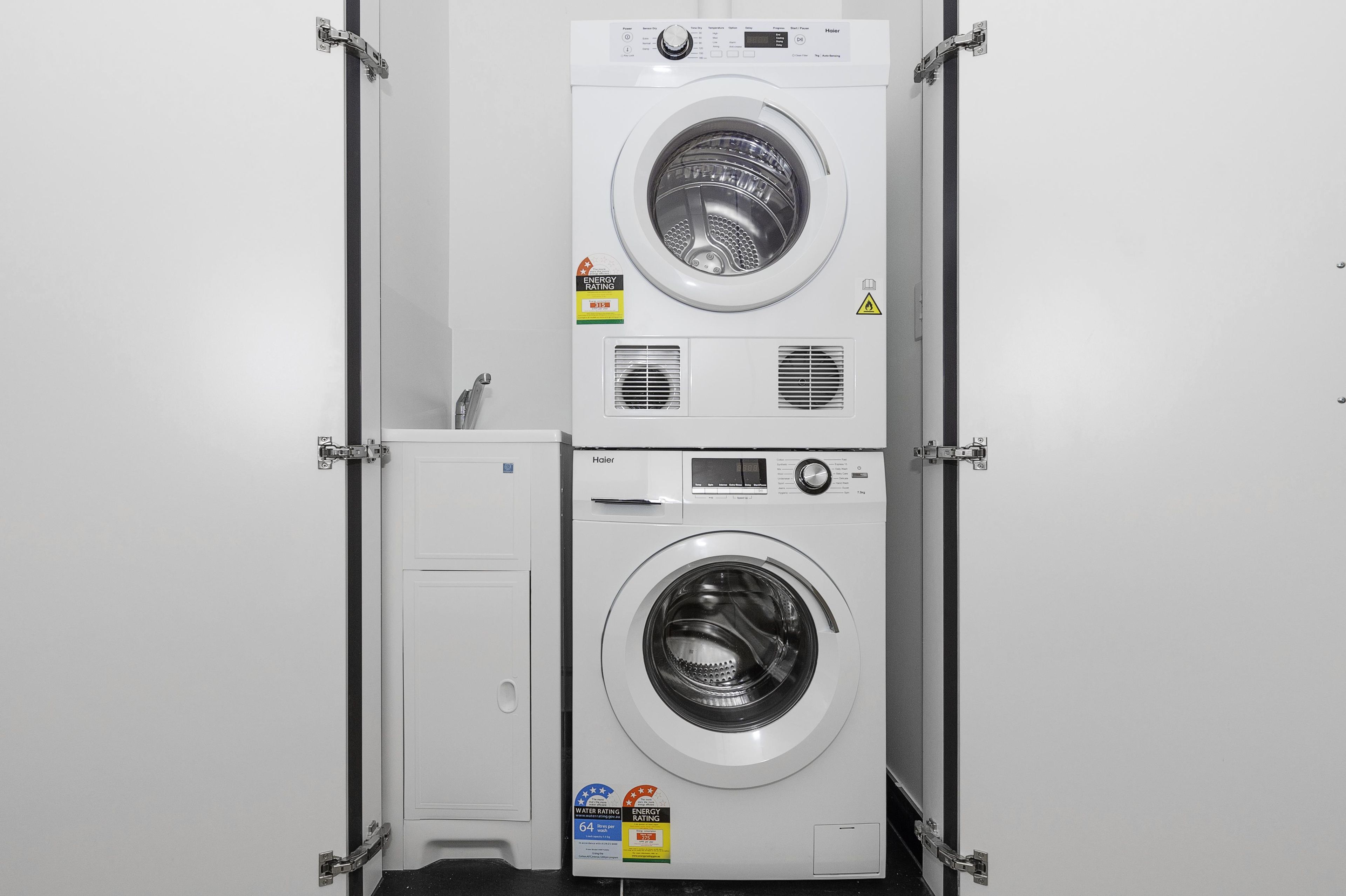 A stacked washer and dryer unit with energy and water rating labels.