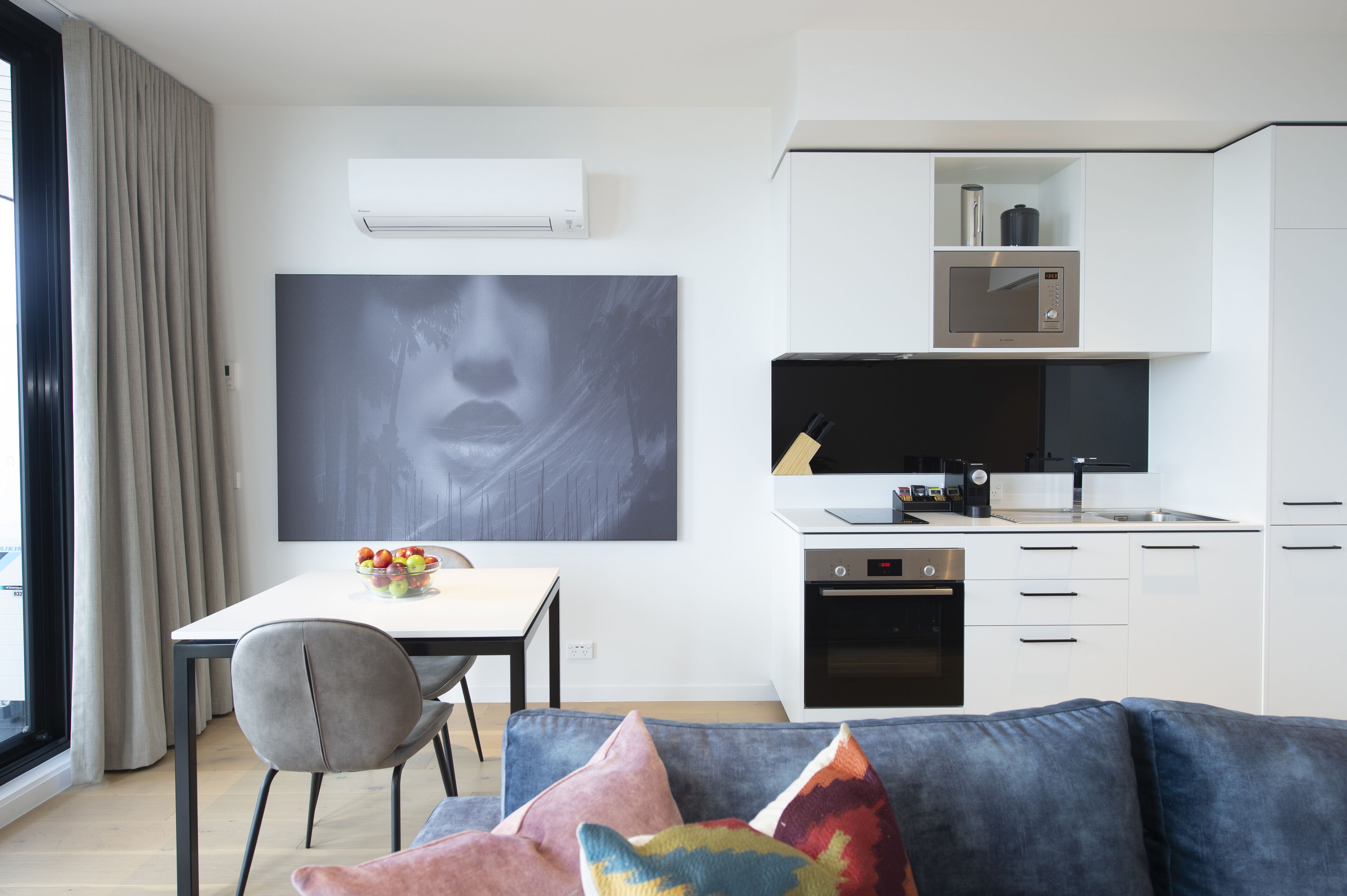 A modern kitchen with white cabinets, a built-in microwave, and a dishwasher.