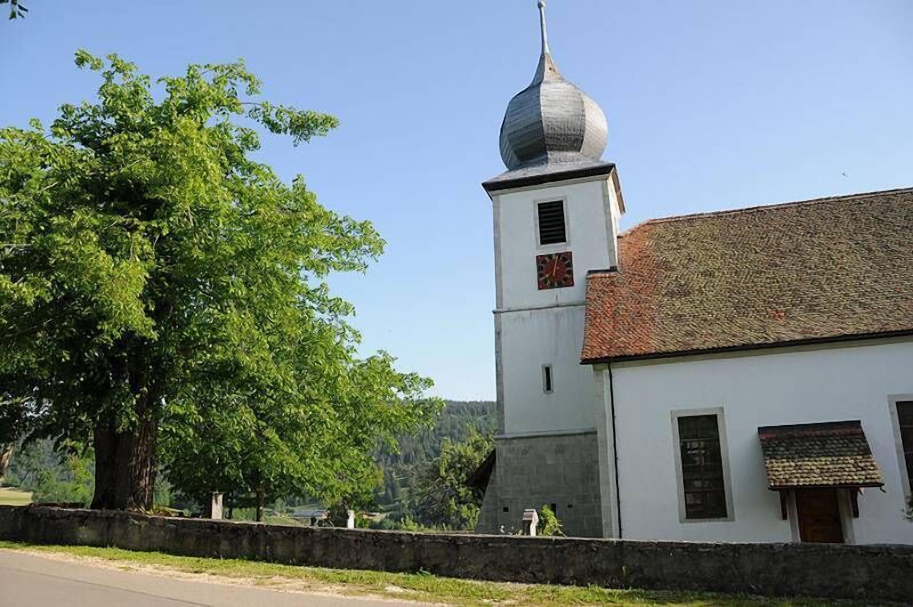 Ein weißes Gebäude mit einem Glockenturm und einem roten Dach.