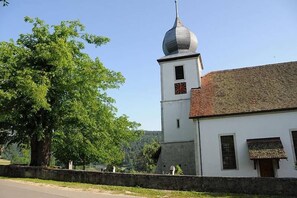 Un edificio blanco con una torre de reloj y un tejado rojo.