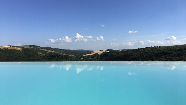 A clear blue pool reflecting the surrounding landscape.