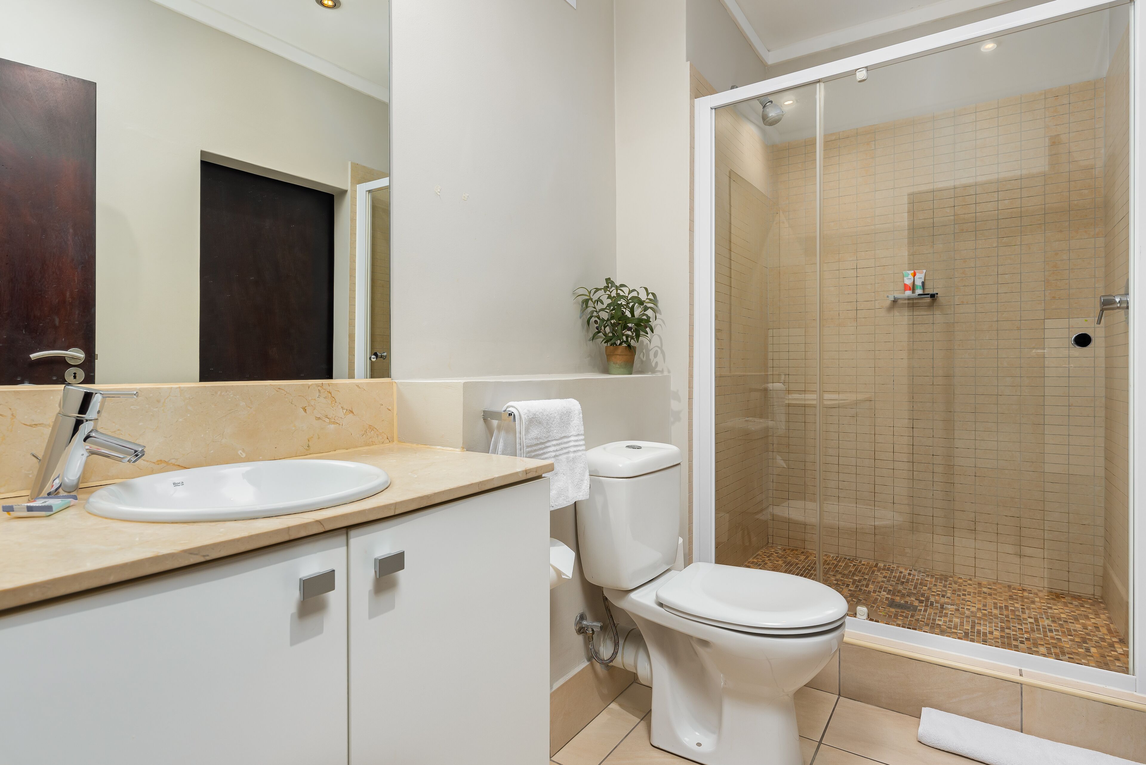 Une salle de bain moderne avec un lavabo, des toilettes et une douche à parois de verre.