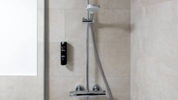 A modern shower with a handheld showerhead and a wall-mounted control panel.
