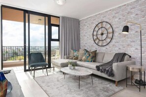 A modern living room with a sofa, coffee table, and a large window with a view.