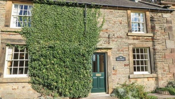Un bâtiment en pierre avec une porte verte et une enseigne sur laquelle on peut lire « Hillcrest ».