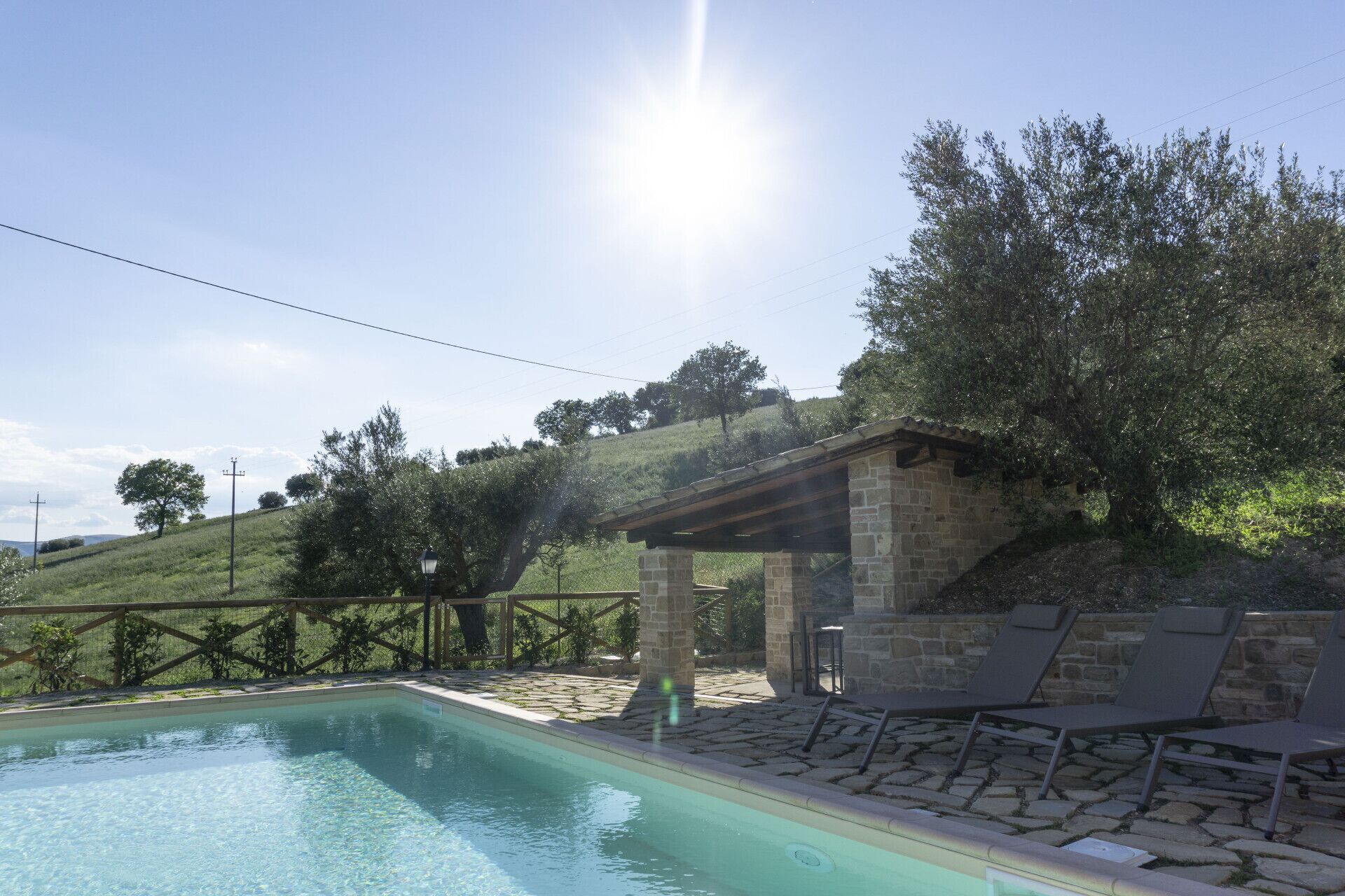 A swimming pool with lounge chairs and a stone structure.
