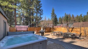 A backyard with a hot tub, picnic table, and chairs. - Red Robin W  Hot Tub Retreat Near Big Bear Lake (Big Bear Lake)