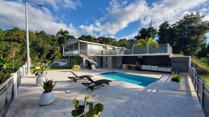 A modern house with a pool, outdoor seating, and a covered barbecue area. - Palm's Bohemian House with Private Pool (Aguada)