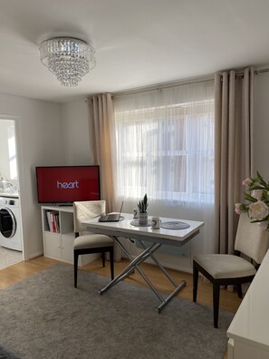 Relax in this stylish living room with a flat-screen TV, dining area, and modern amenities.
