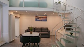 Ein modernes Interieur mit Essbereich, einer Couch, einer Treppe und einem Stadtbild.
