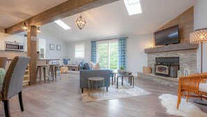 Un salón amplio con chimenea, comedor y cocina equipada con microondas.