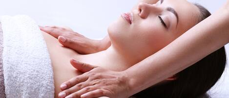 A person receiving a massage with a towel draped over their body.