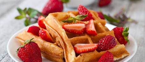 Una porción de gofres cubiertos de fresas.
