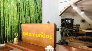 Un comptoir d'accueil avec une enseigne indiquant « Hôtel Rotamundos » et un objet décoratif posé sur le comptoir.