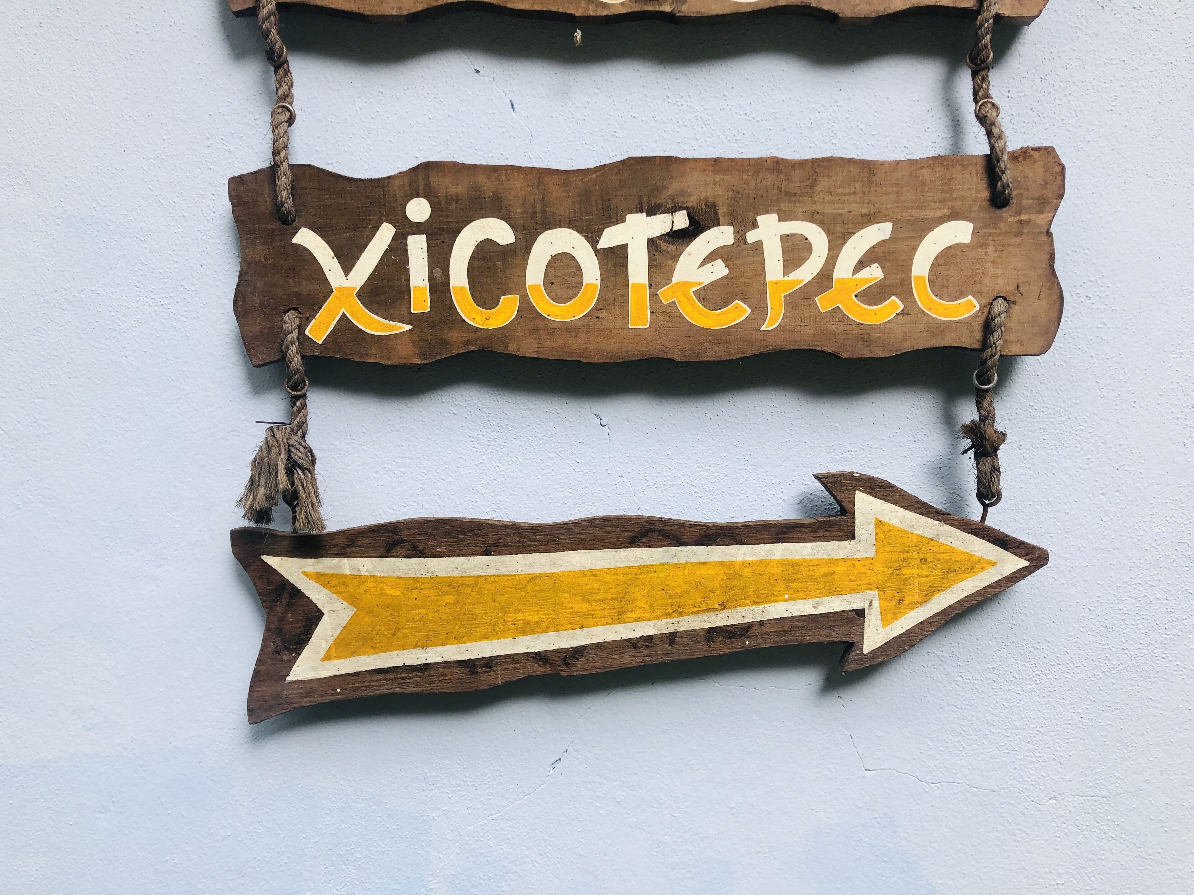 Un letrero de madera con el texto 'Xicotepec' y una flecha indicando dirección a la derecha.