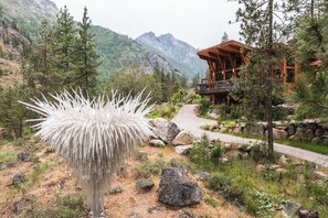 A lodge with a wooden exterior, surrounded by a mountainous landscape and a distinctive white plant in the foreground. - Sleeping Lady Mountain Resort & Spa (Leavenworth)