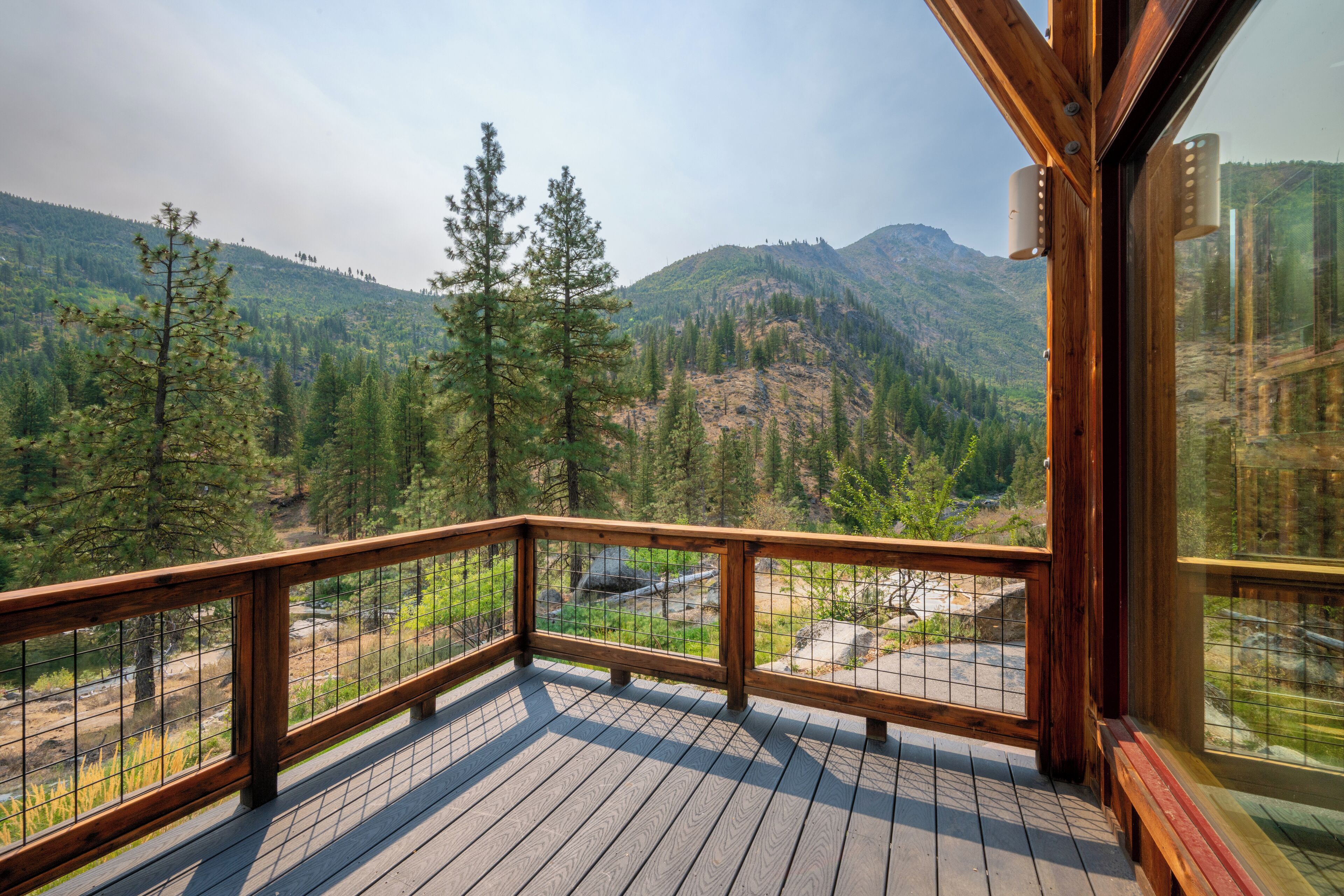 A wooden deck with a view of a mountainous landscape.