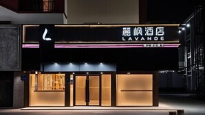 A hotel entrance with a modern facade, illuminated signage, and a glass door entrance. - Lavande Hotel (Zhuhai Gongbei Port Plaza Light Rail Terminal Store) (Zhuhai)