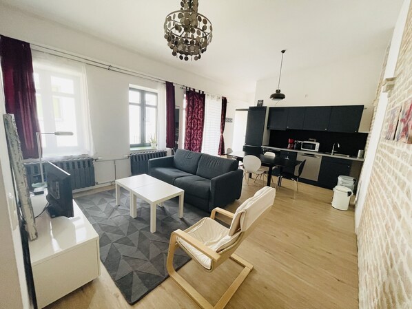 Una sala moderna con sofá, mesa de centro y comedor con mesa y sillas.