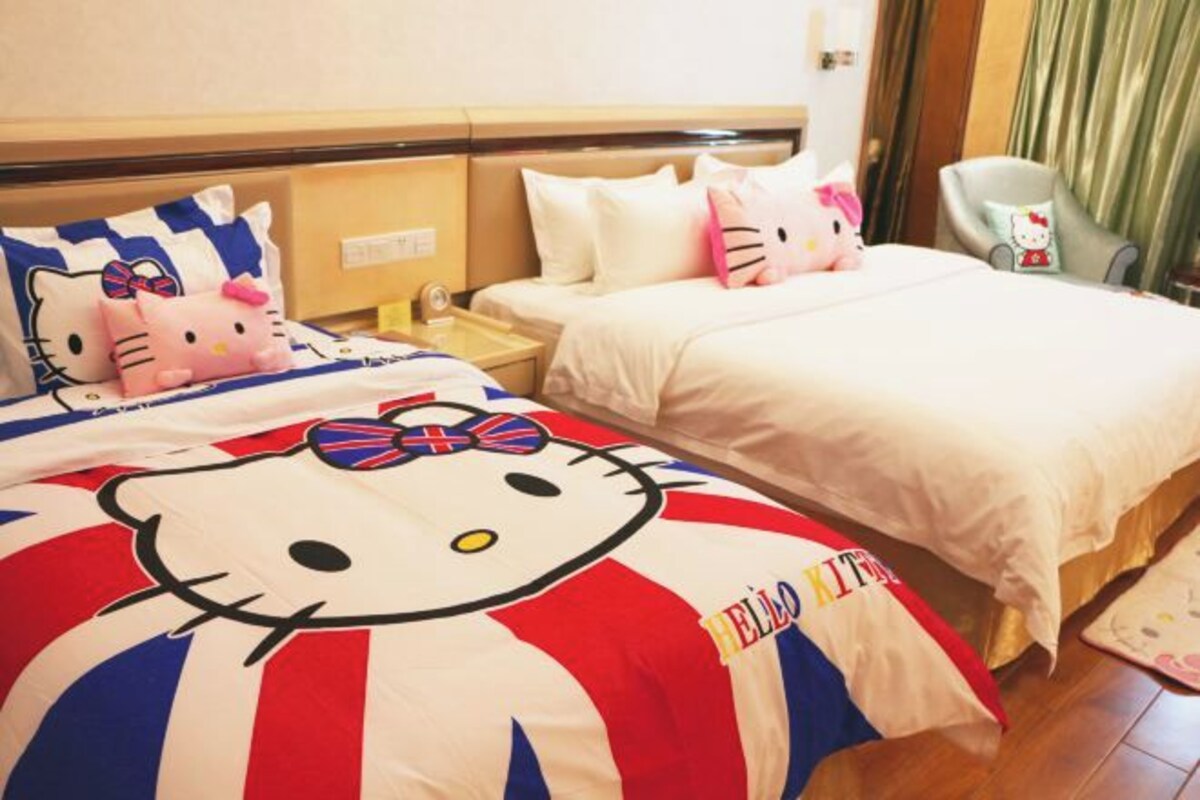 Une chambre d’hôtel avec deux lits, chacun agrémenté de linge de lit aux motifs de Hello Kitty.