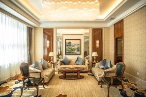 A spacious living room with a large chandelier, a sofa set, and a coffee table. - Fuyue Hotel (Shanghai)