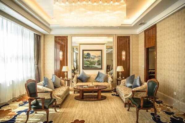 A spacious living room with a large chandelier, a sofa set, and a coffee table. - Fuyue Hotel (Shanghai)