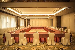 A conference room with a long table, white chairs, and a carpeted floor. - Fuyue Hotel (Shanghai)