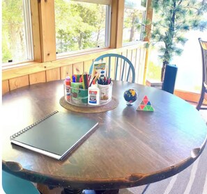 A wooden table with a notebook, a globe, and stationery items.