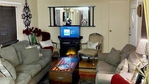 A living room with a sofa, armchairs, a coffee table, a fireplace, and a television. - Three Mile Lake -WATERFRONT and completely Furnished lake house . (Port Barre)