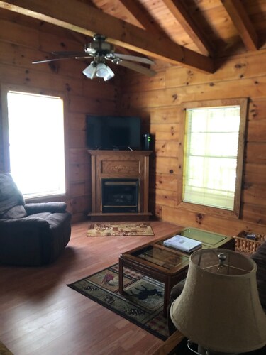 cozy cabin in the woods in a relaxing area with wrap around porch rocking chairs