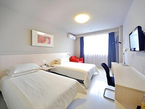 A hotel room with two beds, a desk, a chair, a TV, and a window with curtains. - Jinjiang Inn (Wuhan)