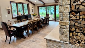 Un comedor con una larga mesa de madera, sillas y una chimenea de piedra.