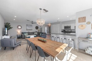 A modern kitchen with a microwave, stove, and bar seating.