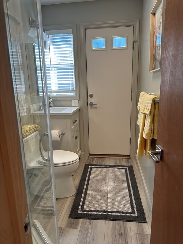 Un baño con inodoro, lavamanos y zona de ducha.