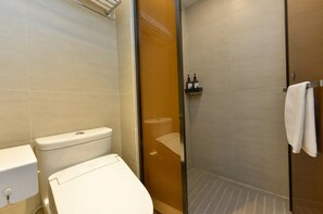 A bathroom with a toilet, a shower enclosure, and a towel rack. - Ji Hotel (Shanghai)