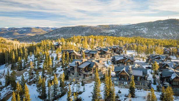 A resort with multiple wooden cabins surrounded by snow-covered trees and mountains in the background. - 🏆 Breck Ski Views | Gondola Access | Hot Tub | 3 Kings | Sleeps 8 (Breckenridge)