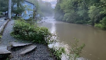 A river with a gravel path and trees on one side.