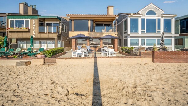 A beachfront property with a patio area featuring outdoor seating and a barbecue grill. - 2 Bed Oceanfront w/ patio on the Sand in Quiet West Newport (Newport Beach)