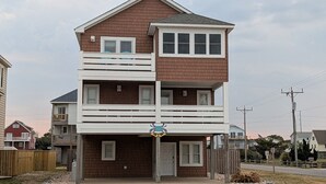 Un immeuble résidentiel de deux étages doté d’un balcon, d’un garage et d’une allée.
